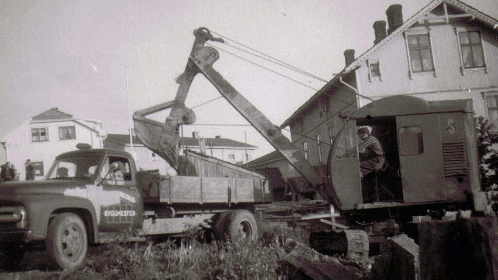 Gammalt svartvitt foto av lastbil och grävmaskin